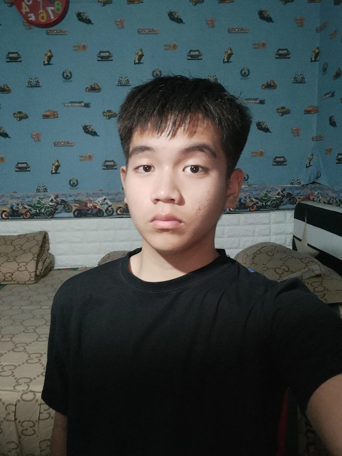 Fakhri taking a selfie in a black T-shirt at home.